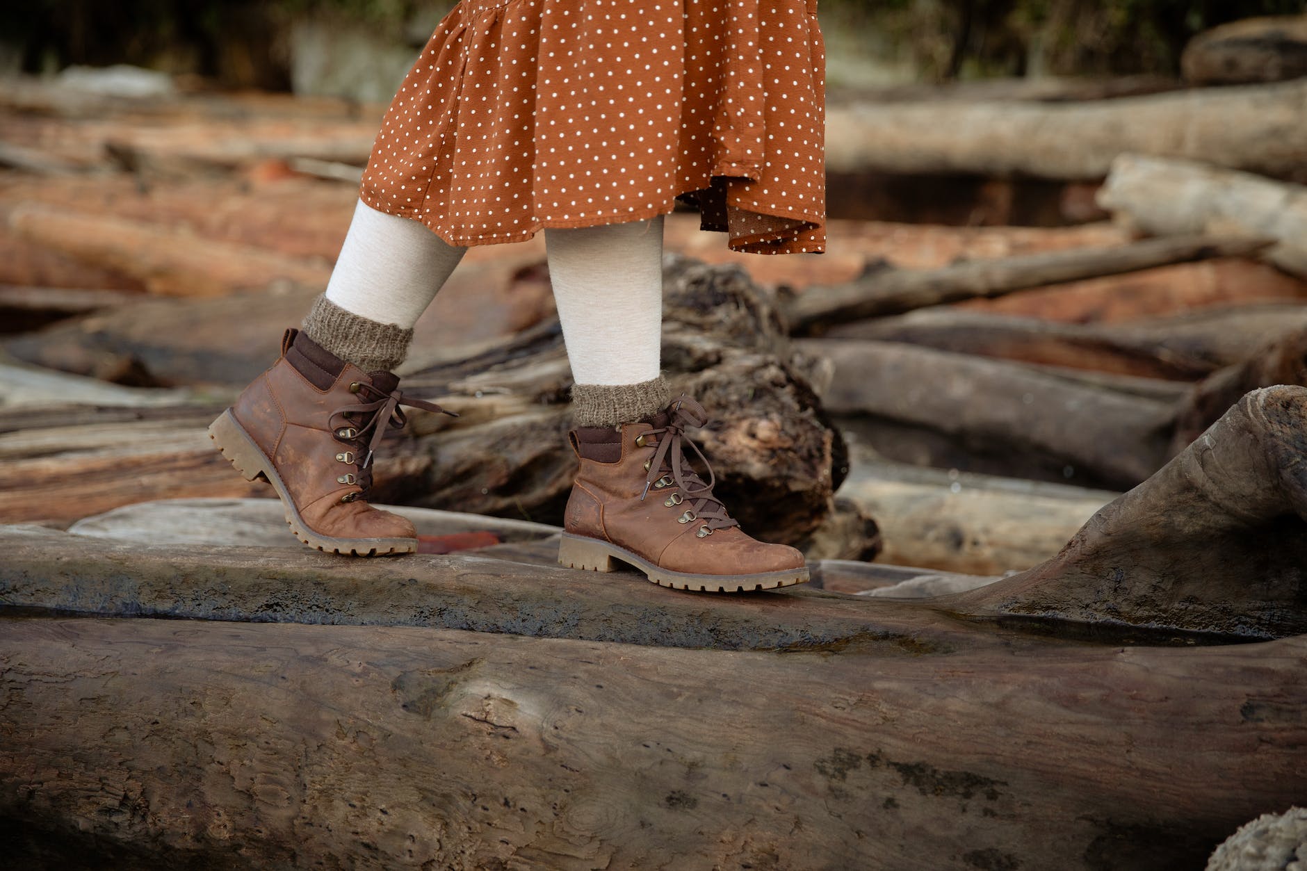 unrecognizable crop woman walking on log near forest