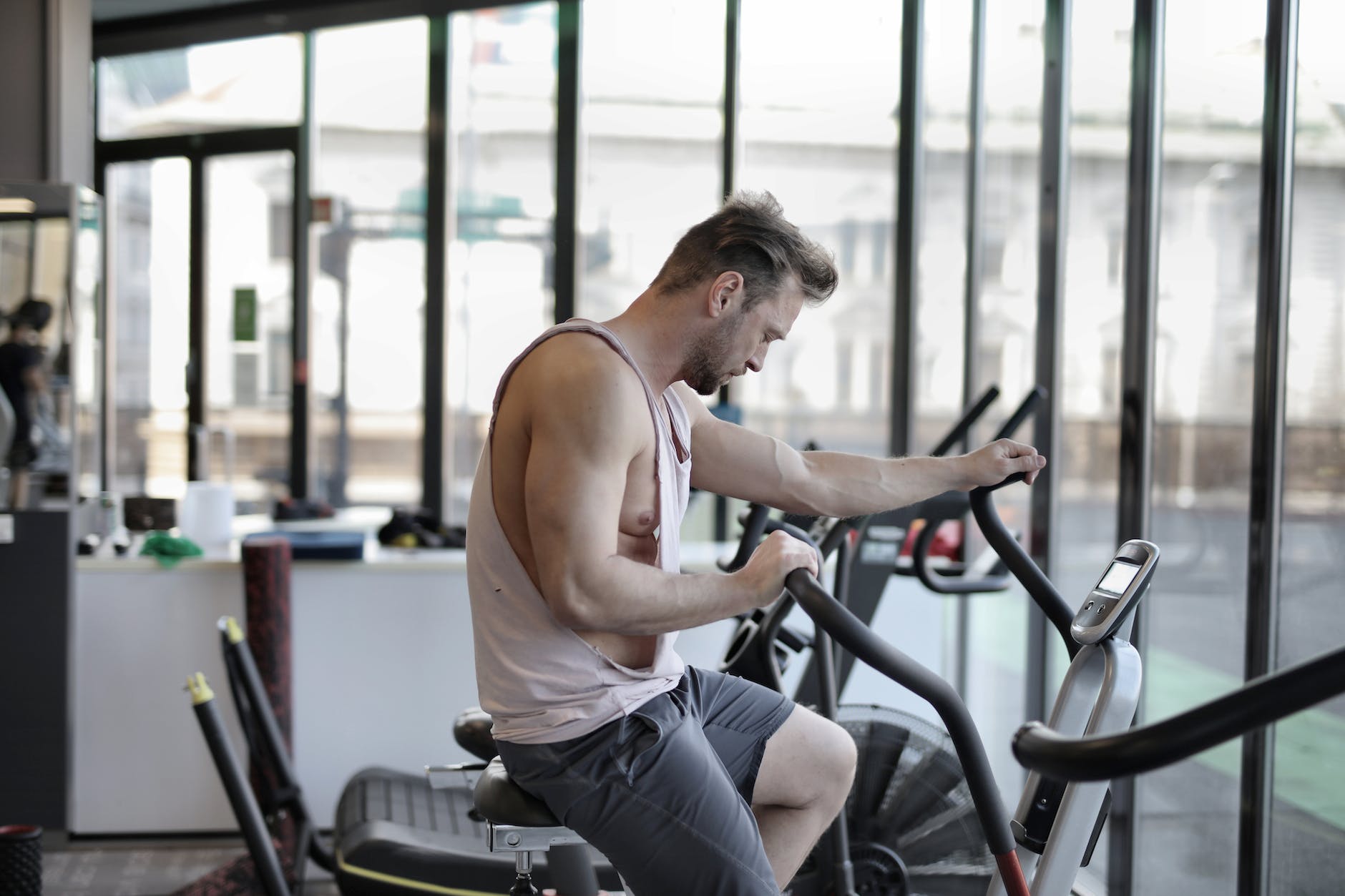 exhausted athletic man training on exercise bike