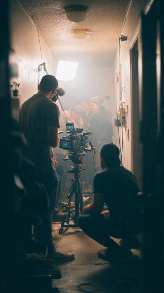 Candid BTS shot of small team setting up camera and sound gear in tight space.
