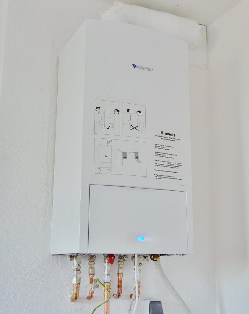 "A modern water heater with a digital display panel, showing temperature and settings, indicating a smart device.