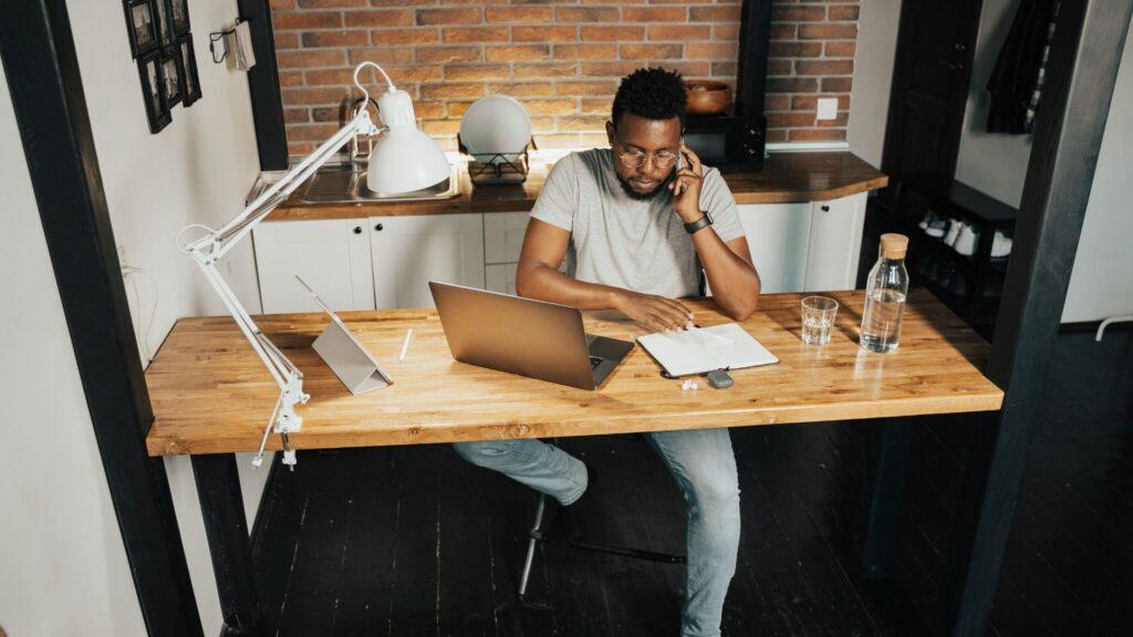Man sitting at his computer desk next to his computer