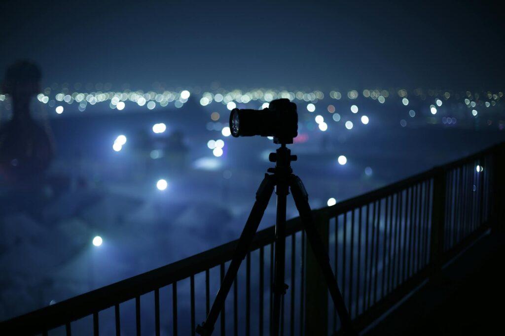 travel filmmaking digital camera on tripod beside hand rail