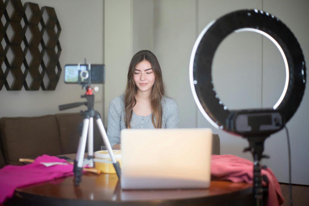 Woman vlogging in front of a smartphone camera with ring light lighting