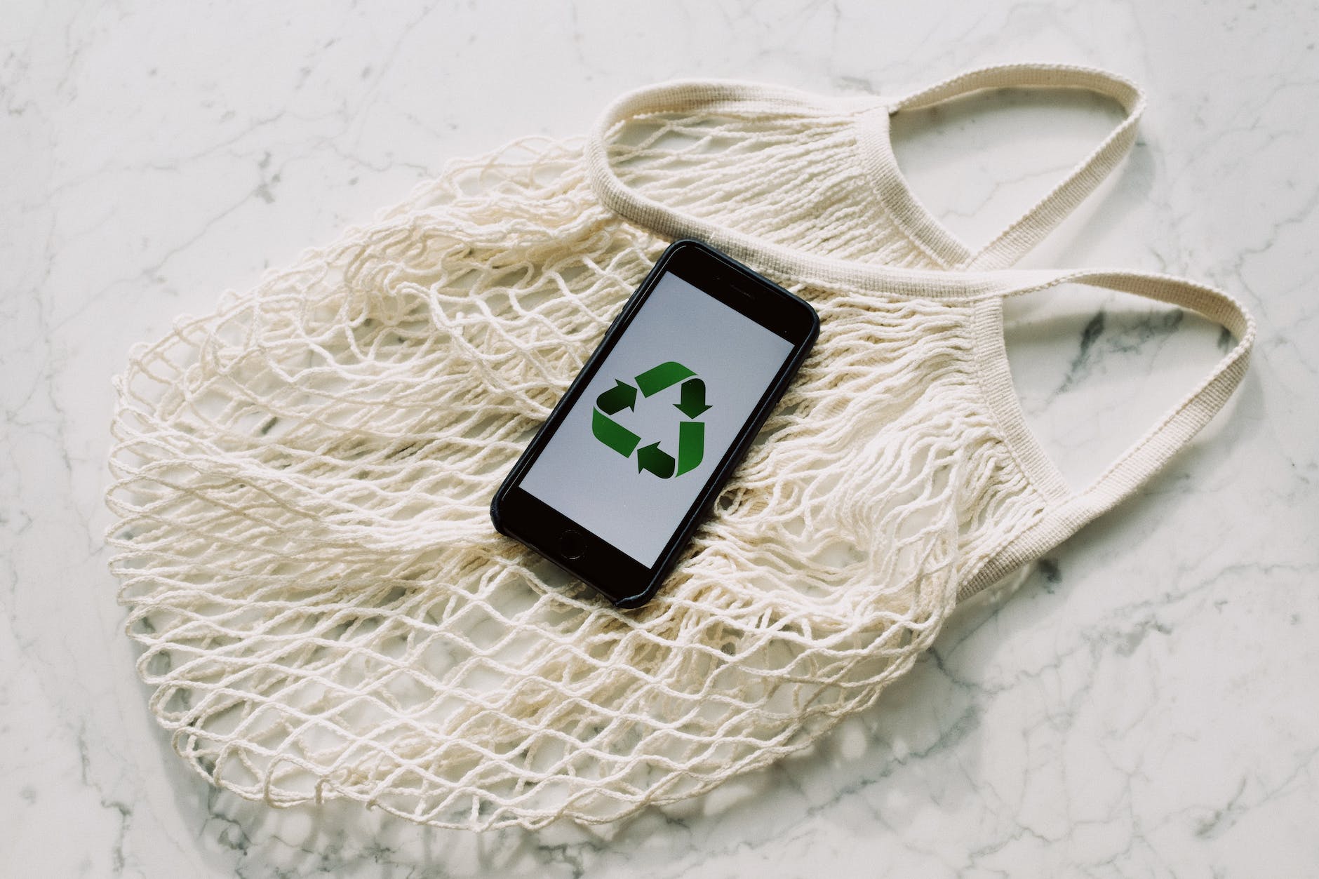 Smart Ways To Make Your Home More Eco-Friendly - mobile phone with green recycling sign and mesh bag