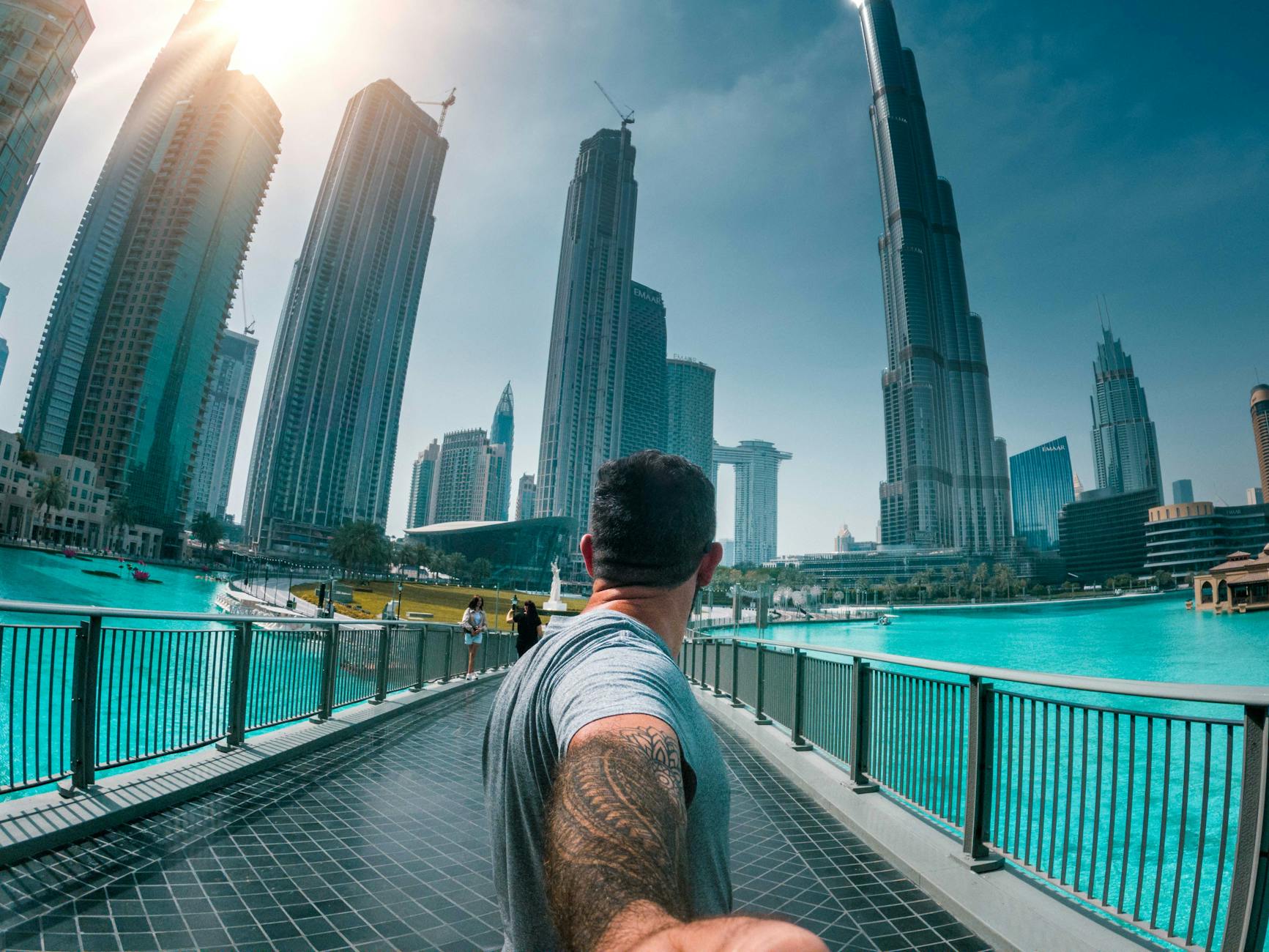 solo travel vlogging man in grey t shirt crossing a foot bridge
