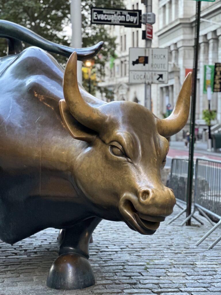 The iconic bronze Charging Bull sculpture, a symbol of financial optimism, located in the heart of Wall Street.