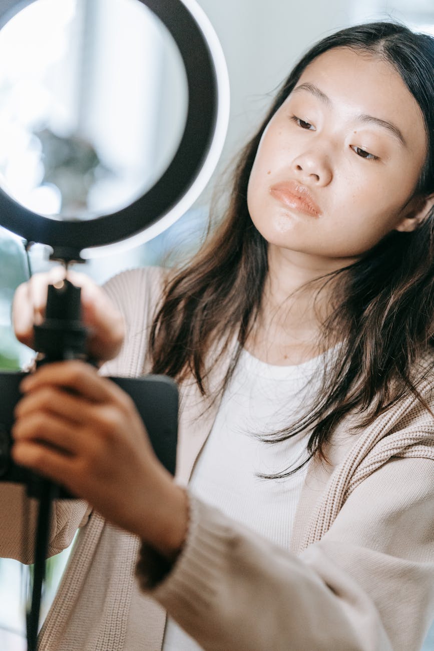 pretty woman holding a ring light with cellphone
