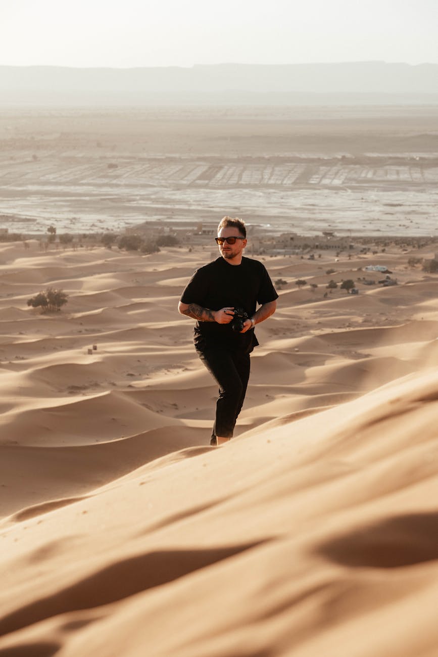 man climbing on dune