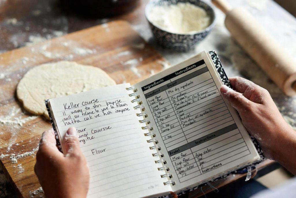 Handwritten cooking notes from Thomas Keller MasterClass with printed recipe PDF and active kitchen setup