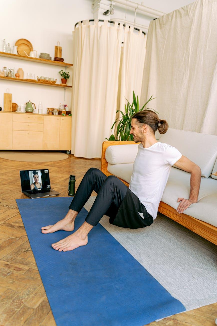 stay fit a man doing exercise at home while in a video call