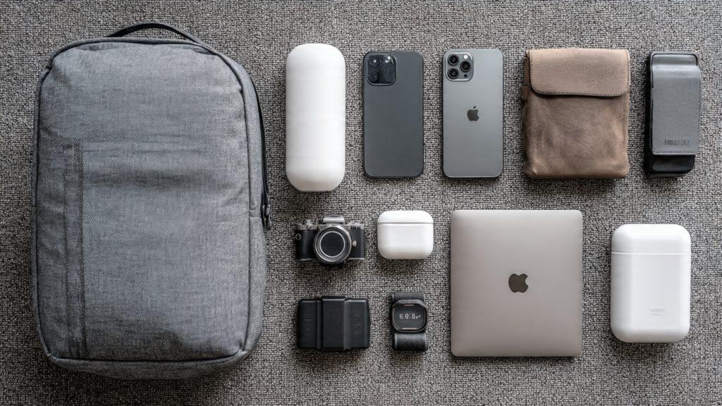 Nomad gear essentials: A flat lay of the mentioned gear (portable router, power bank, adapter, etc.) on a minimalist travel desk or backpack