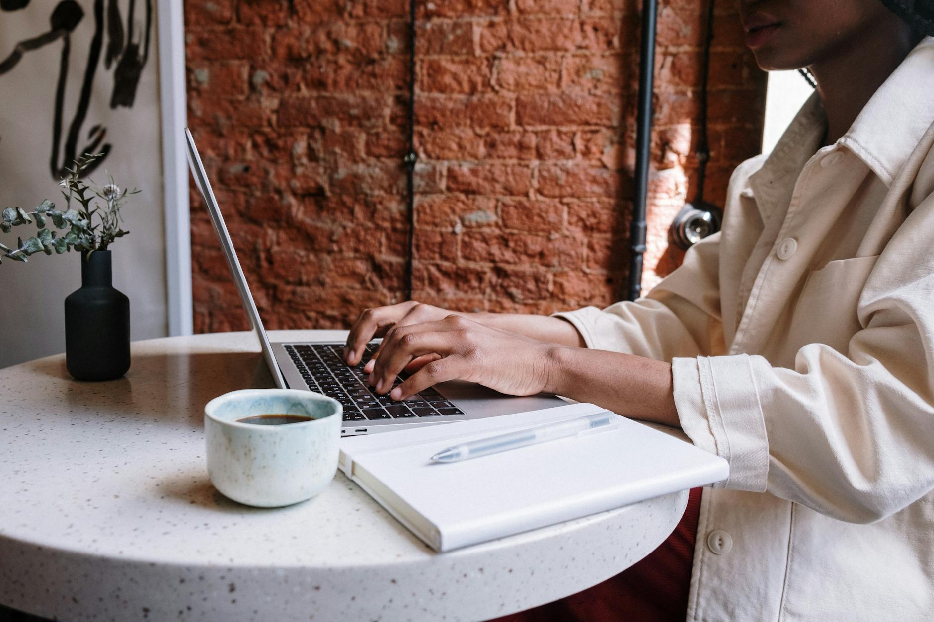 person in white long sleeve shirt using macbook pro using wi-fi